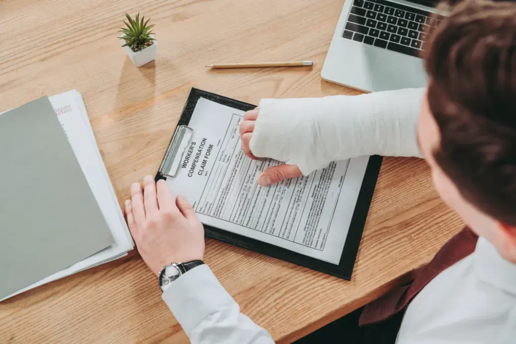 Person with arm cast reviewing compensation claim form